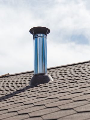 Chimney pipe from stainless steel on the roof of the house.