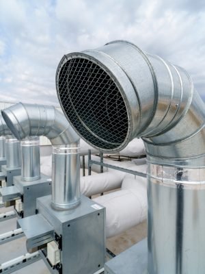 The air conditioning and ventilation system of a large industrial building is located on the roof. It consists of air ducts, air conditioning, smoke removal and ventilation